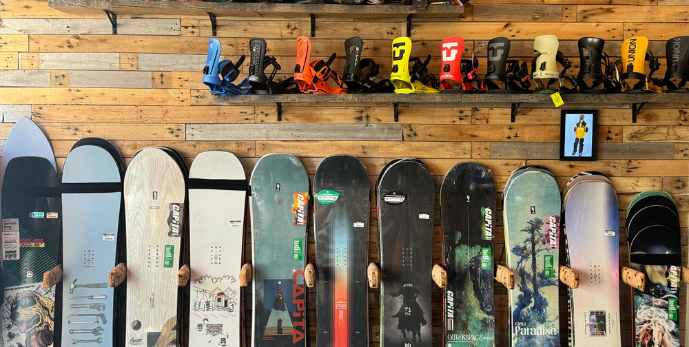 Wall of snowboards and bindings inside One80 Boardshop in Oudenaarde